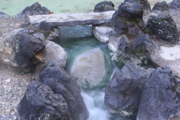 Emerald water rushing through the rocks
