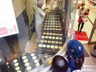 School children looking at the process of baking Pekko-chan Yaki.