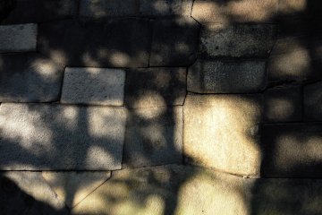 <p>A modern abstract art work: the surface of stonewalls reflecting sunshine in the garden</p>