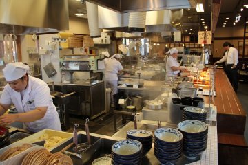 <p>The mesmerizing activity in the kitchen tends to slow down the line of customers that enjoy the show rather than slide their tray to the cash register</p>
