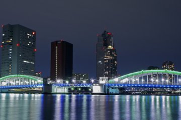<p>Night-time green lights illuminate the water front and&nbsp;Kachidoki Bridge</p>