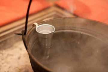 <p>Heating sake in boiling water over the fire.&nbsp;</p>