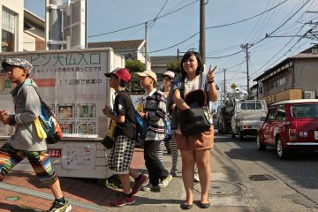 <p>นักเรียนชาวญี่ปุ่นเดินเรียงแถวกันมาทัศนศึกษาที่เมืองคามาคุระ</p>
