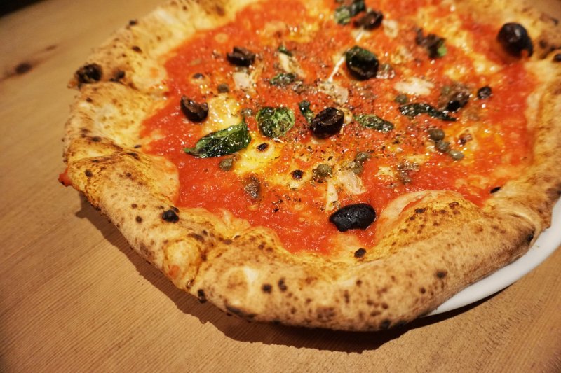 Pizza Siciliana straight out of the authentic Italian wooden kiln. Featuring tomato sauce, oregano, basil, garlic, olives, anchovy and caper.